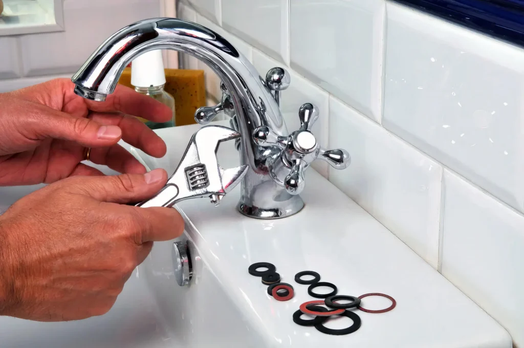 Plumber performing maintenance on a bathroom faucet in Escondido